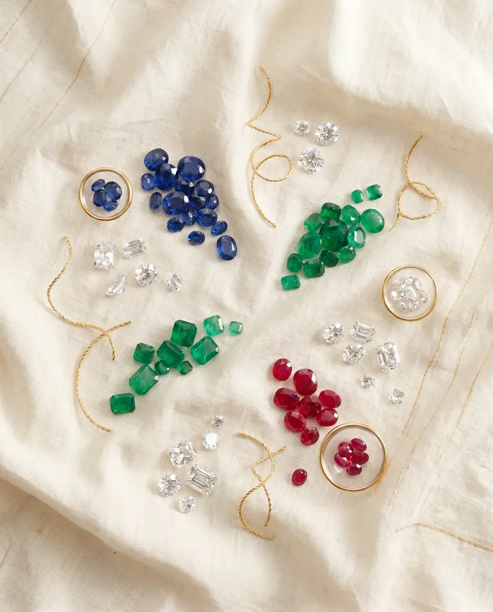 A curated collection of fine loose gemstones — sapphires, emeralds, rubies, and diamonds
